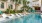 a pool with chairs and trees by it
